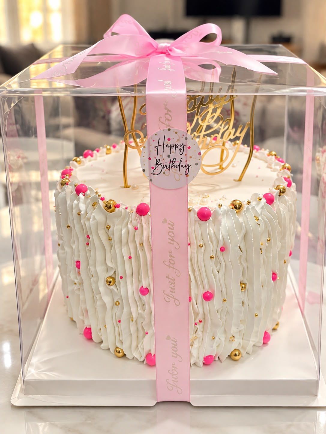 White ruffle birthday cake with pink and gold pearls in a gift box